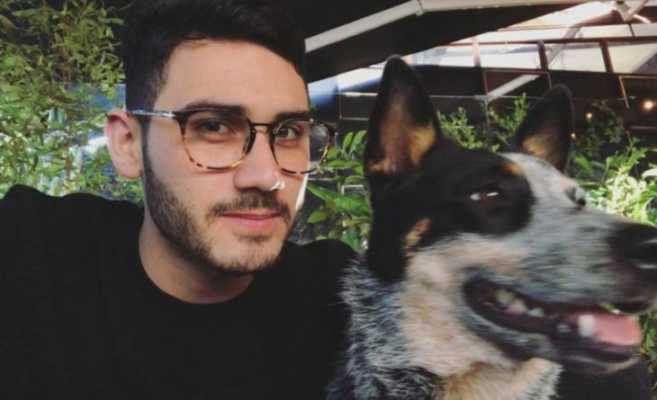 Alejandro Speitzer posando para fotografía, al lado de su perro y usando un suéter negro