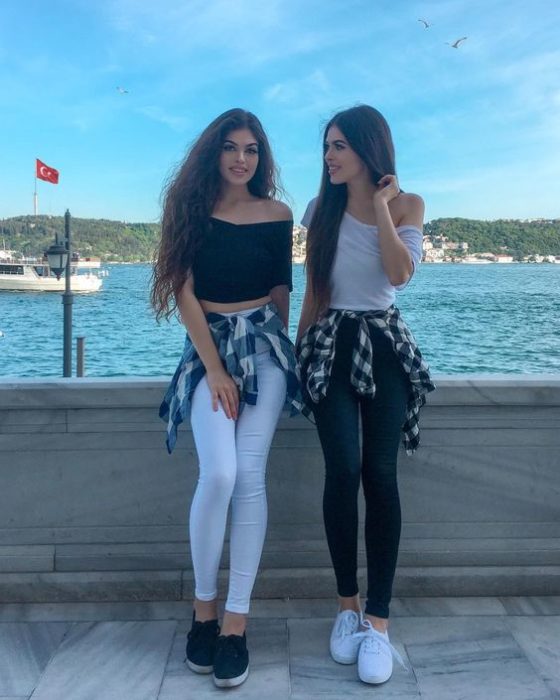 Mejores amigas con outfits iguales de pantalón negro y blusa blanca