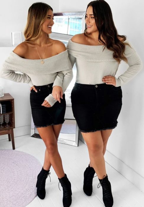 Mejores amigas con outfits iguales de falda negra y blusa gris de manga larga