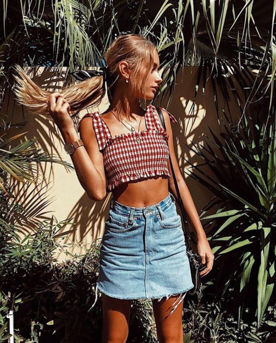 Chica usando mini falda y crop top con tirantes