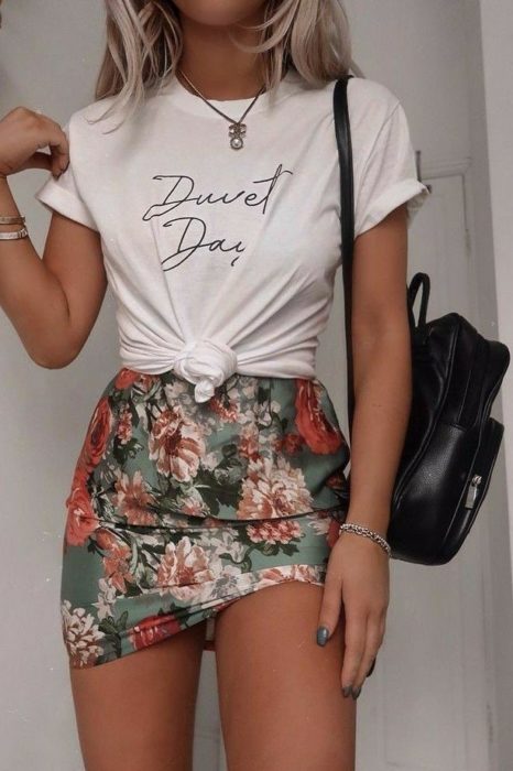 Chica usando mini falda floreada con blusa blanca anudada