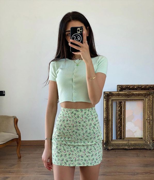 Chica usando mini falda color menta con flores y blusa de tejido del mismo color con botones al frente