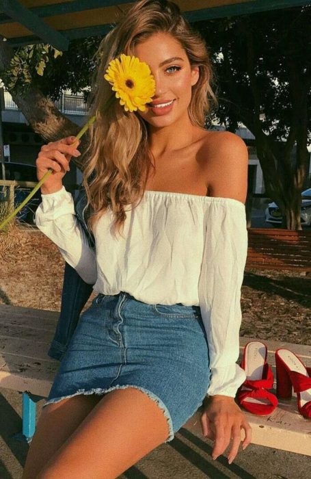 Chica usando mini falda tipo denim y blusa off the shoulder color blanco