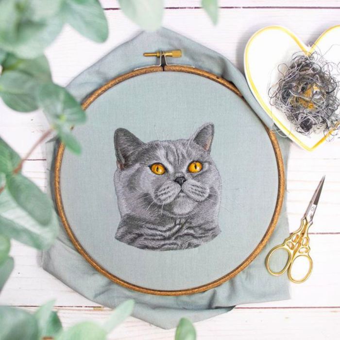 Artista Michelle Staub hace bordados de mascotas; bordado de gato gris con ojos amarillos