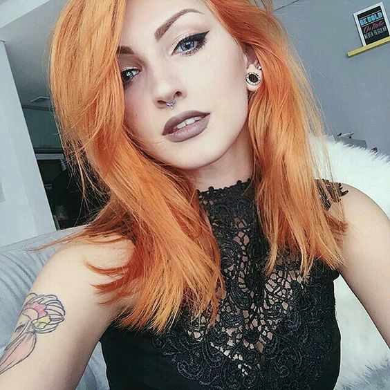 Chica tomando una selfie mostrando su cabello teñido en tono peachy copper