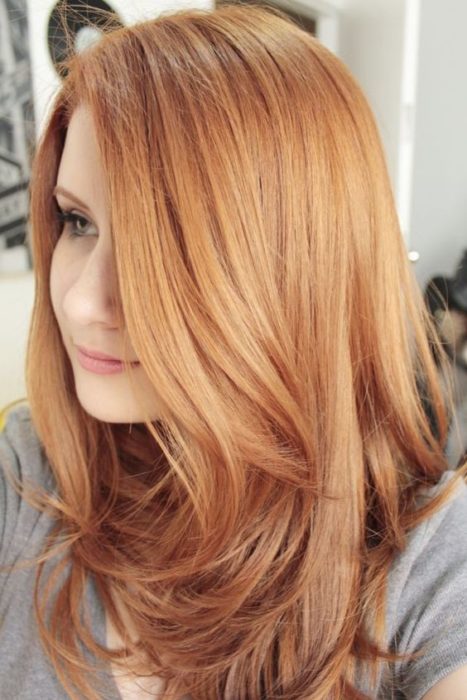 Mujer d eperfil mstrando su cabello peachy copper