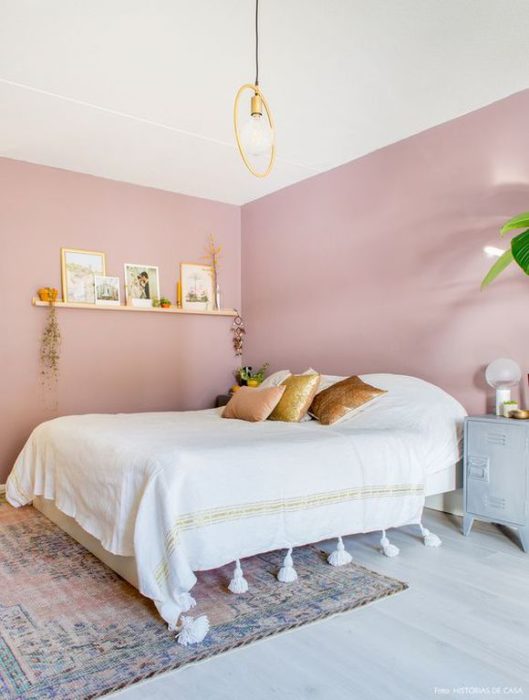 Habitación rosa con una cama de color blanco