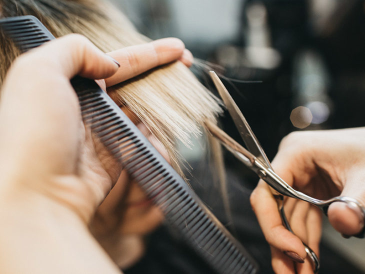 Estilista realizando despunte en cabello