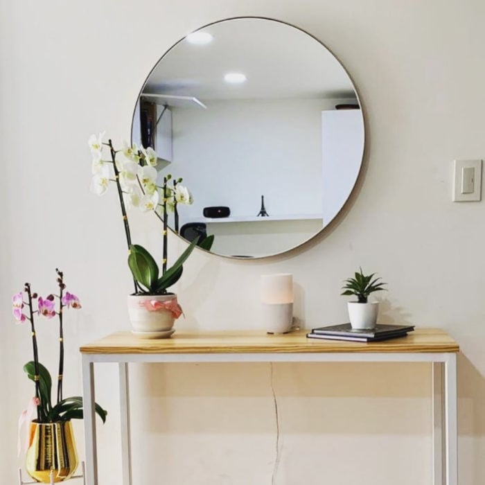Artículos de decoración para el hogar; espejo grande y redondo con escritorio sencillo y macetas con flores