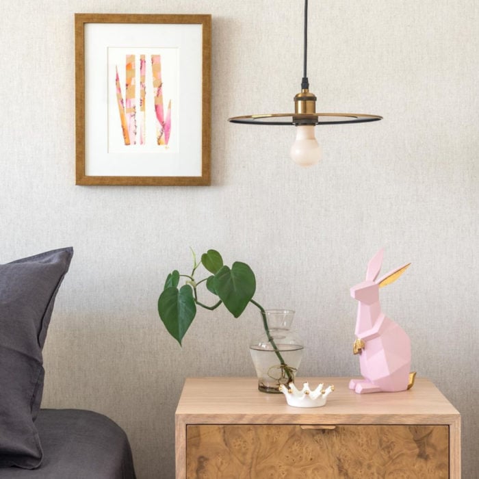 Artículos de decoración para el hogar; estatua de conejo geométrico rosa sobre mesa de noche con maceta