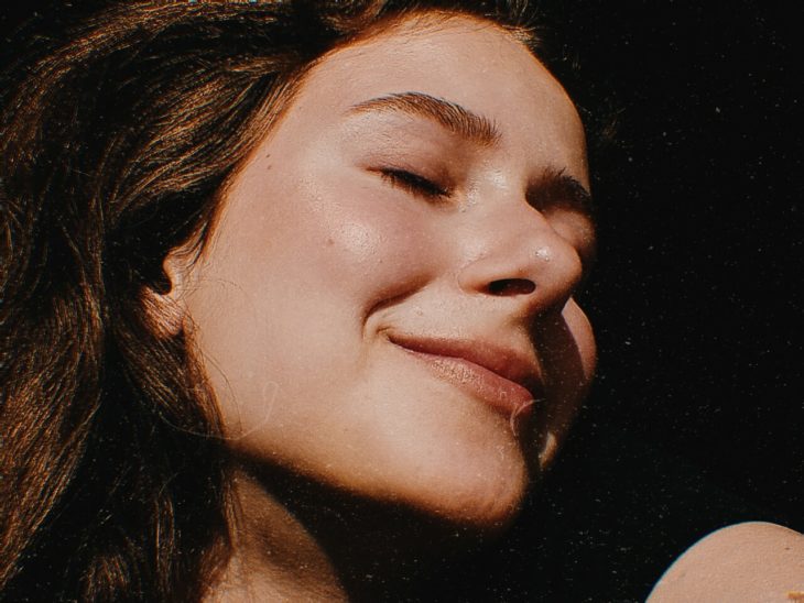 Rostro de una chica de cabello castaño con los ojos cerrados