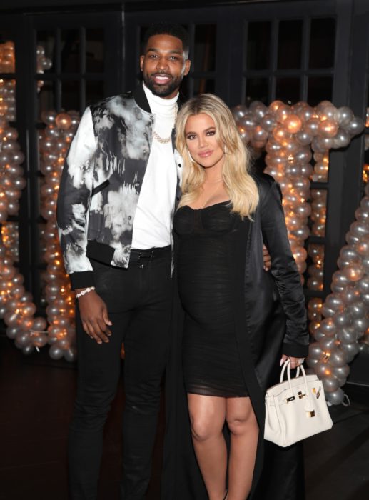 Khloé Kardashian y Tristan Thompson abrazados mientras están en una fiesta