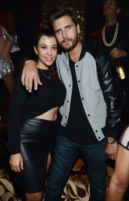 Kourtney Kardashian y Scott Disick abrazados posando para una fotografía mientras están en una discoteca