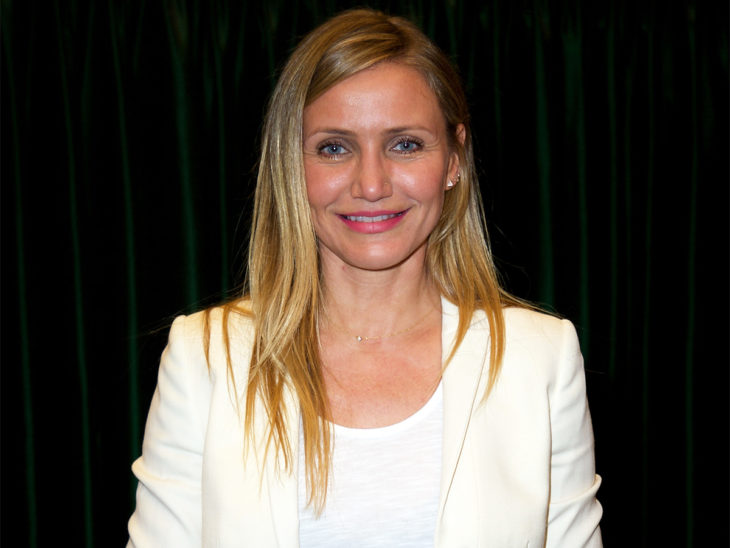 Cameron Diaz usando un traje sastre de color blanco mientras posa para una sesión de fotos en una alfombra roja