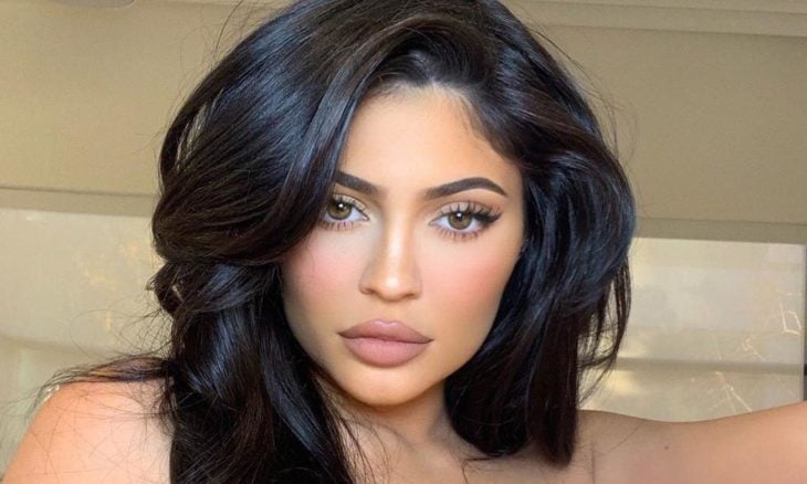 Kylie Jenner posando para una fotografía en la que muestra sus labios y el maquillaje hecho con sus productos