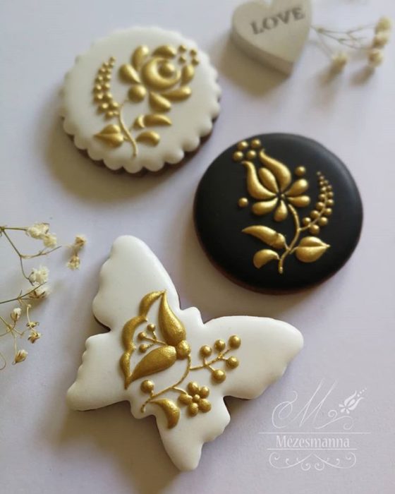 Galleta de jengibre decorada con flores en color dorado