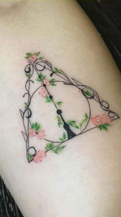 Tatuaje inspirado en Harry Potter, de las reliquias de la muerte decoradas con flores