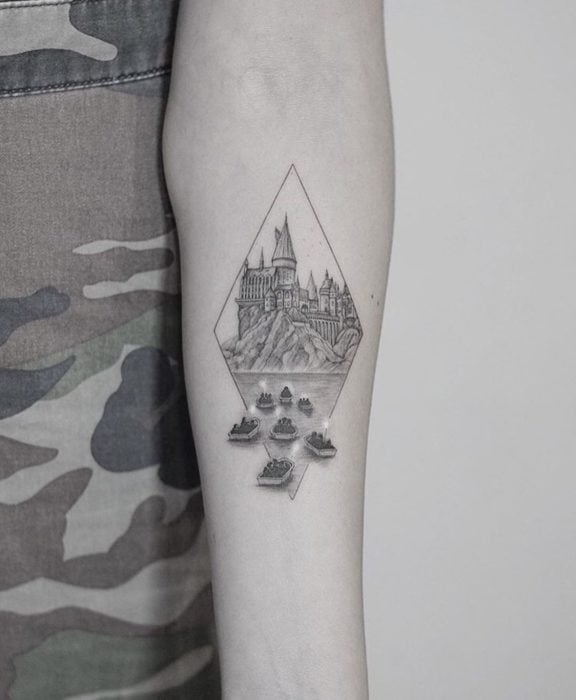 Tatuaje inspirado en Harry Potter, de el castillo de Hogwarts y los botes que llevan a los de primer año
