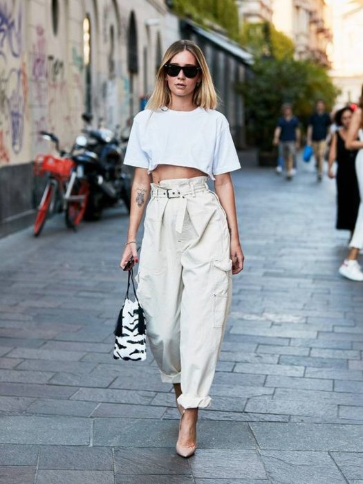 Mujer rubia con crop top blanco y baggy pants beige