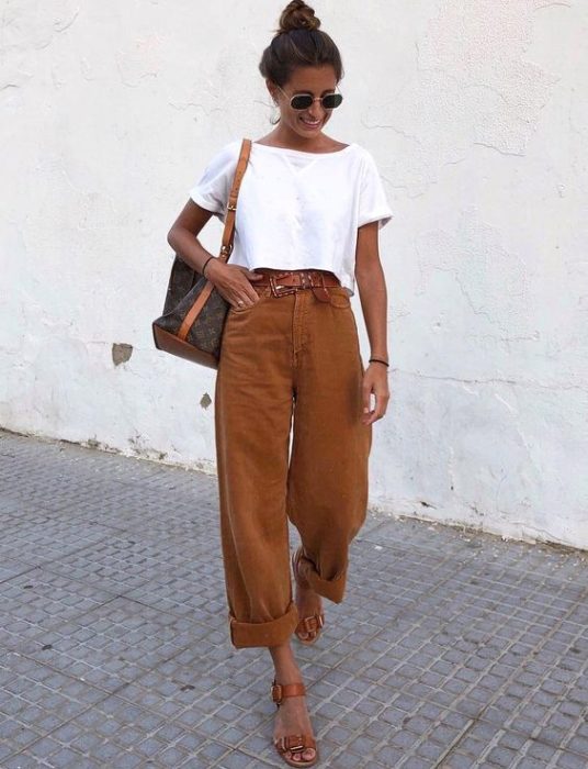 Mujer posando en la calle con blusa blanca y baggy pants camel