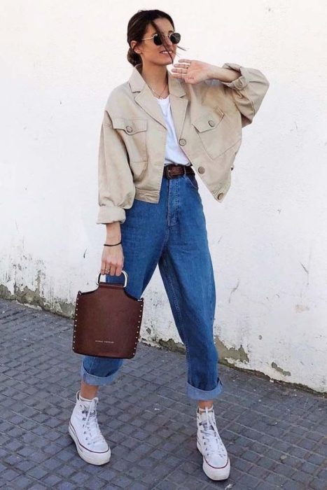 Chica caminando en la calle con baggy pants de mezclilla y chaqueta beige