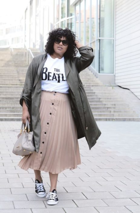 Chica plus size con falda midi rosa con blusa blanca y saco verde 