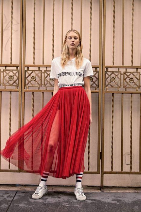 Chica llevando falda plizada en tono rojo con transparencias