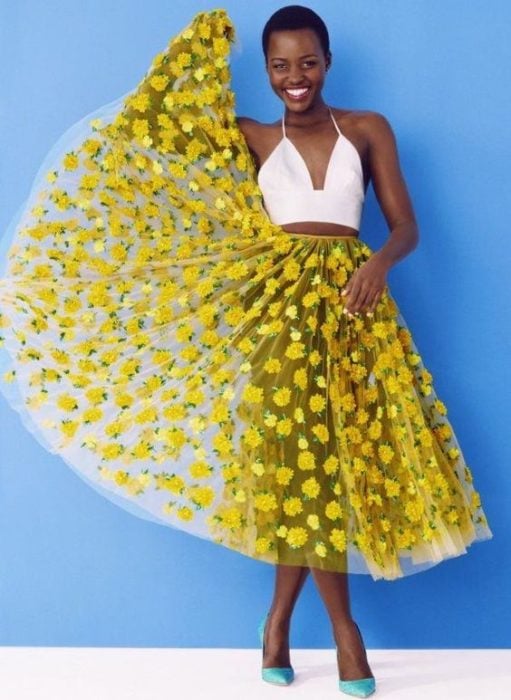 Chica con falda transparente decorada con bordados de flores amarillas