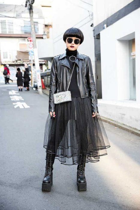 Chica con outfit negro de falda a transparencia y chamarra de cuero oscuro