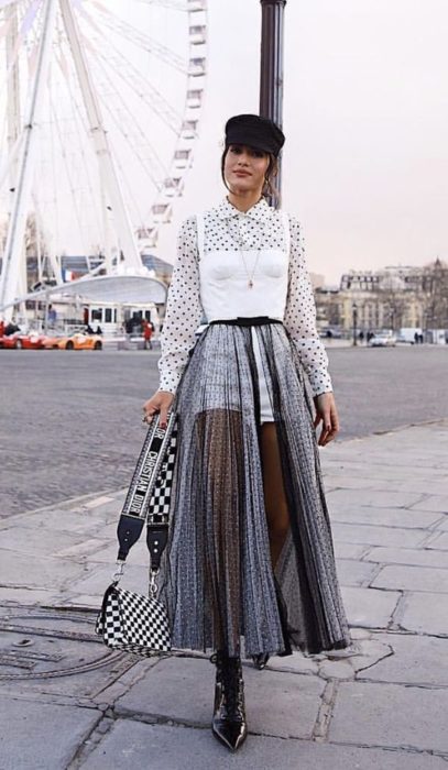 Chica llevando falda a transparencia en color negro con short de mezclilla y camisa blanca