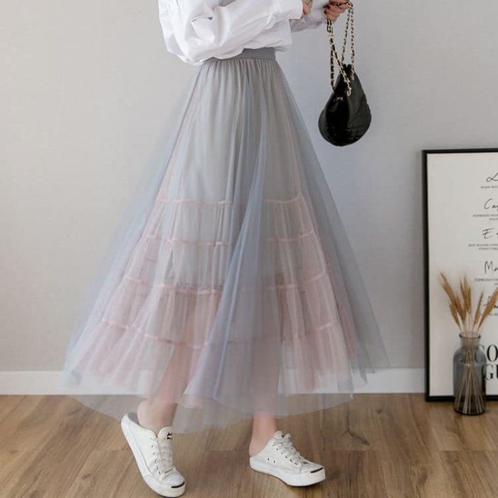 Mujer llevando falda con transparencia en color gris claro con rosa pastel y estrellas plateadas