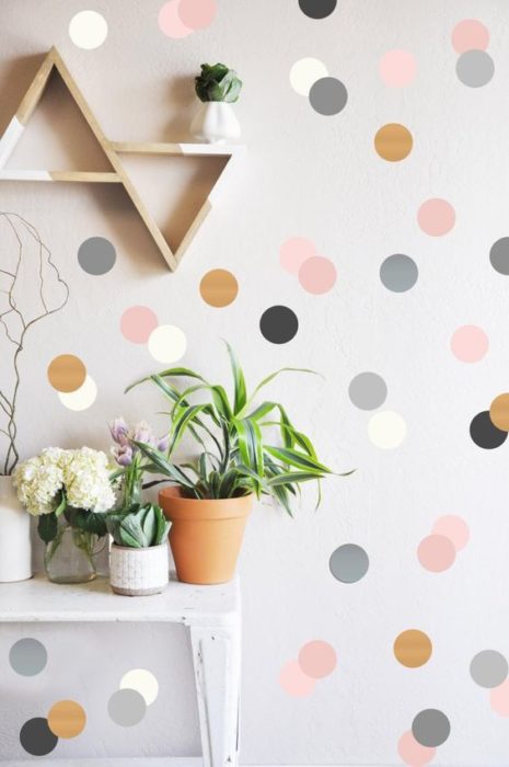 Decoración de pared con fondo gris y puntos rosas, negros, dorados y grises