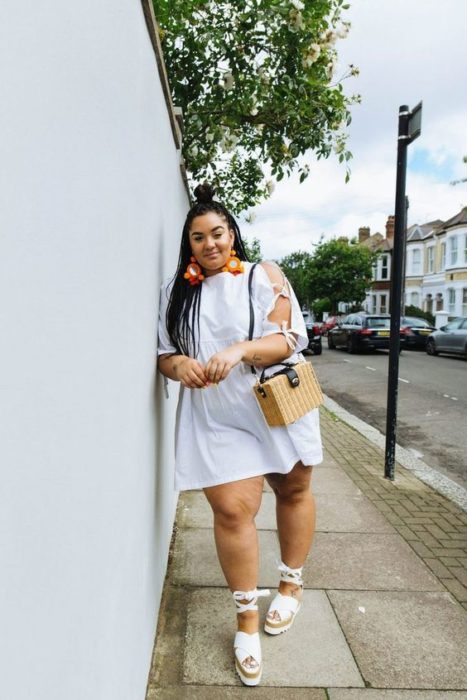 Mujer plus size con vestido blanco y bolso tipo canasta