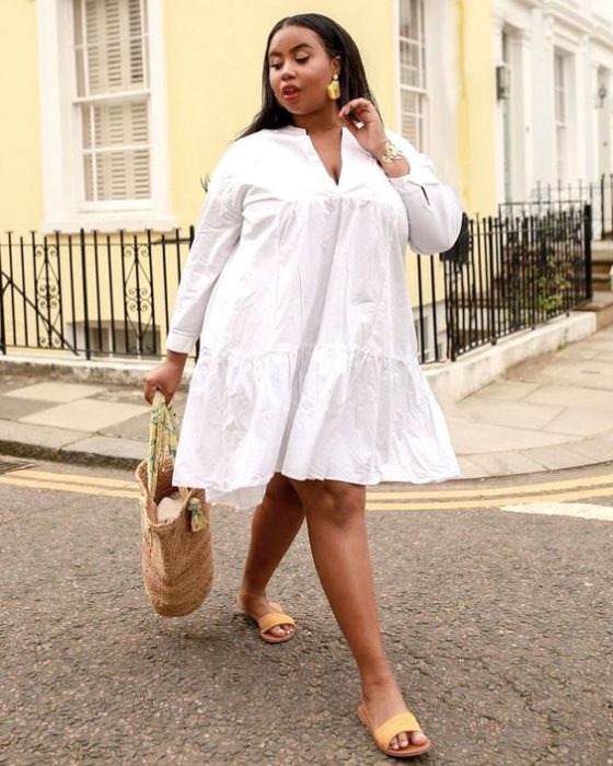 Mujer plus size con vestido blanco y bolso tipo canasta