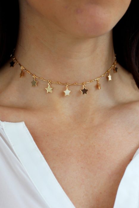 Collar inspirado en el universo con estrellas pequeñas en color dorado y ajustado al cuello