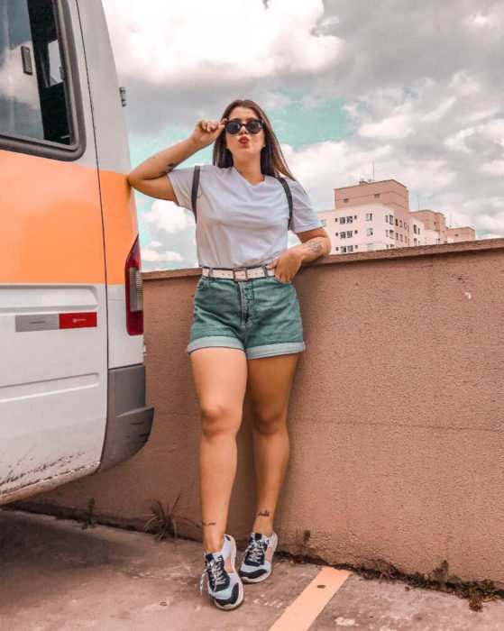 Looks con short vintage; chica vestida casual, con blusa blanca y tenis deportivos, lentes de sol