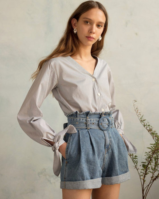 Looks con short vintage; mujer de cabello castaño largo y lacio, con blusa formal