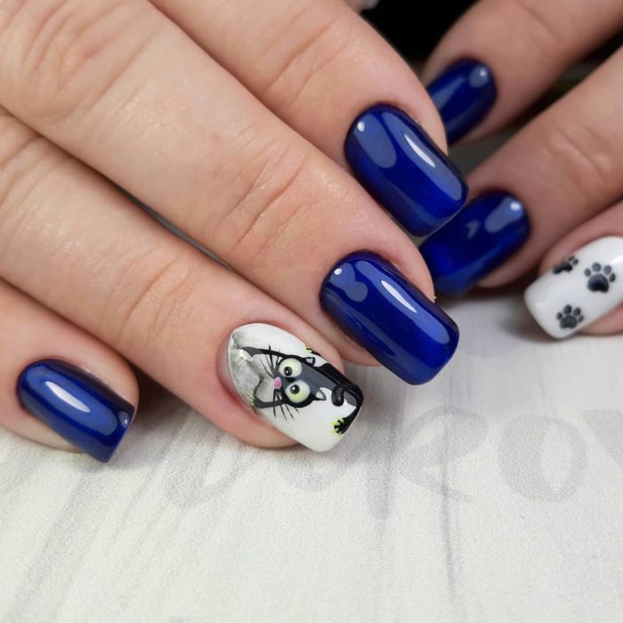 Manicura en tono azul rey con decorado de gato en sticker