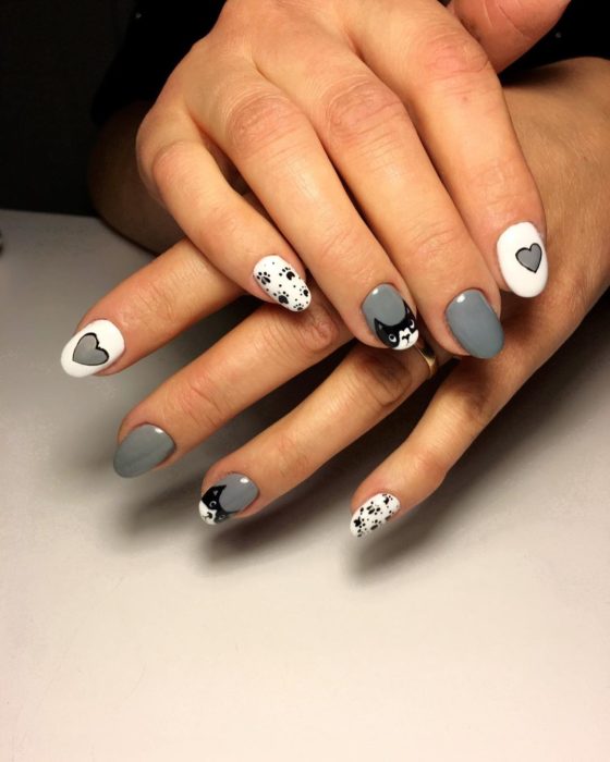 Manicura en colores grises y blancos con decorado de gatos en blanco y negro