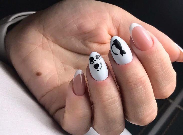 Manicura en color blanco con decorado de silueta de gatos en negro