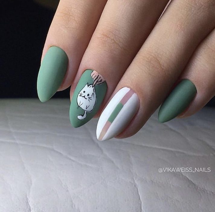 Manicura en color verdo con decorado de gato en blanco y franjas blancas