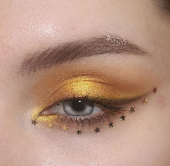 Maquillaje de ojos color amarillo con estrellitas