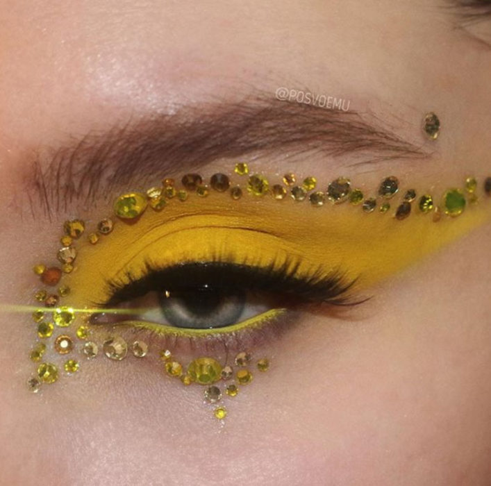 Maquillaje de ojos color amarillo y aplicaciones amarillas