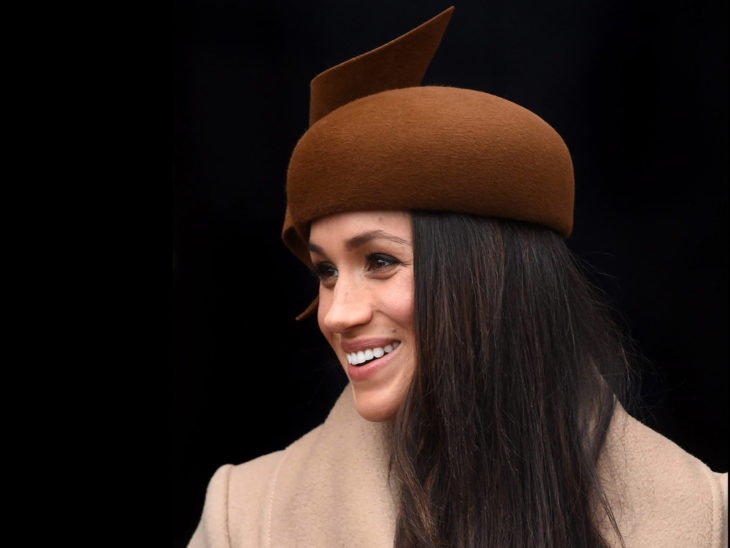 Meghan Markle usando un fascinator color café