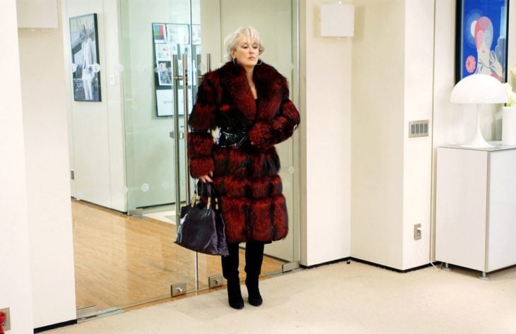 Escena de la película El Diablo Viste a la moda. Miranda usando un abrigo largo de color rojo con negro 