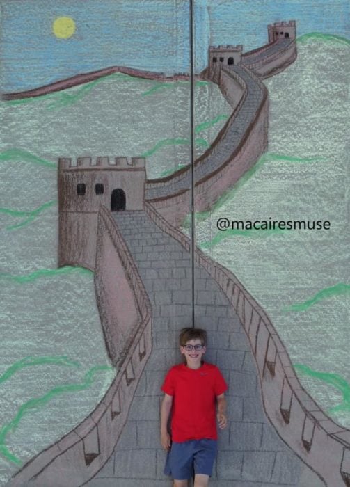 Dibujo de hecho con tiza de un niño caminando por la muralla china 