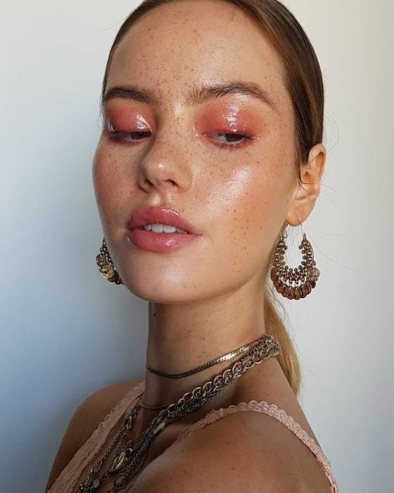 Chica rubia con maquillaje de ojos efecto glossy color naranja