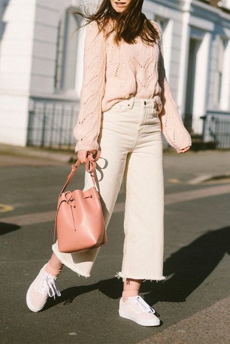 Chica usando jeans rectos con suéter rosa bebé y bucket bag color rosa 