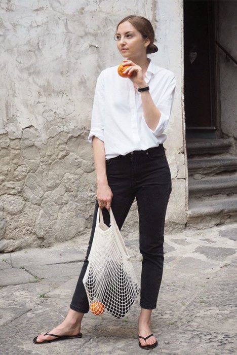 Chica con pantalón negro, blusa blanca y flip flops