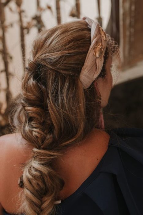 Chica con recogido elegante despeinado con diadema beige con detalles dorados